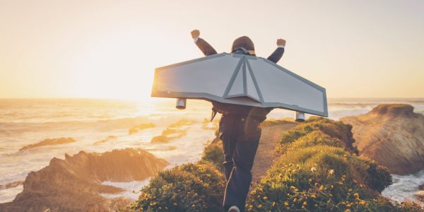 Business Boy with Jet Pack in California A young boy dressed in business suit and tie wears a homemade jetpack and flying goggles raises his arms in the afternoon sun while running to take off into the air on an outcropping above the surf in Montana de Oro State Park, California. This young entrepreneur is ready to take his new business to new heights.